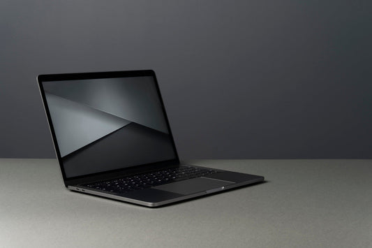 A modern laptop against a monochrome background.